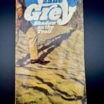 Zane Grey vintage book in front of black background.