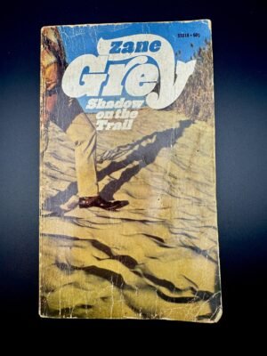 Zane Grey vintage book in front of black background.